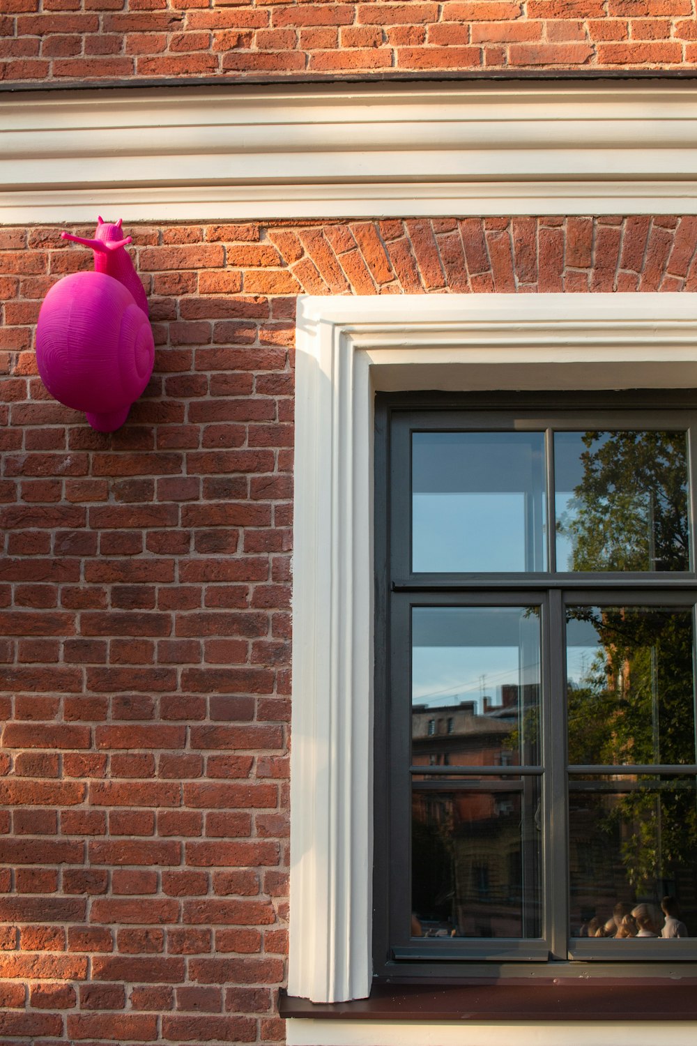 pink plastic bag hanged on brown brick wall