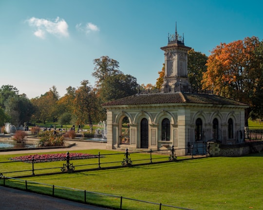 white and brown concrete building near green trees under blue sky during daytime in Kensington Gardens United Kingdom