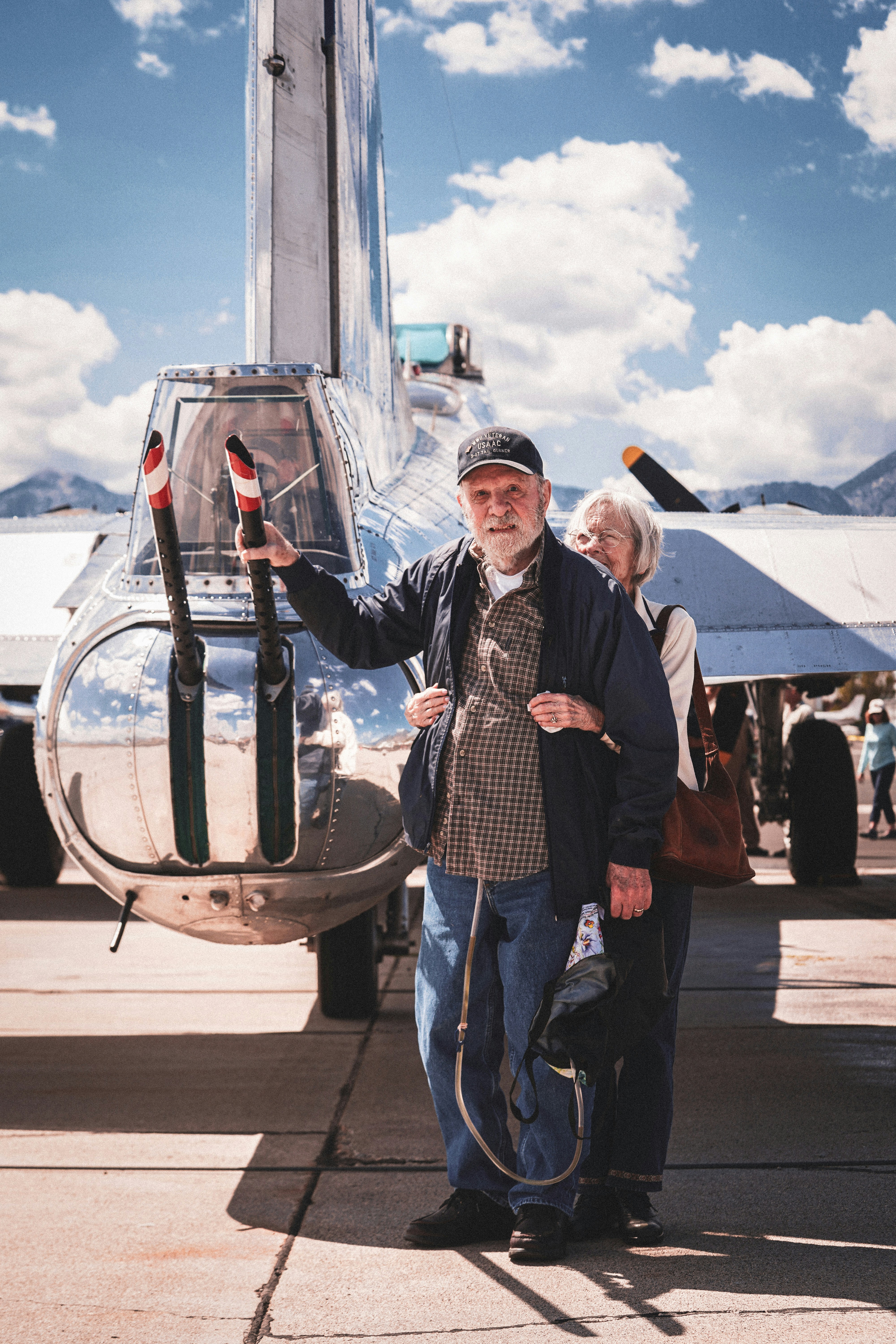 昼間、灰色の金属フレームのそばに立つブルーデニムジーンズの男