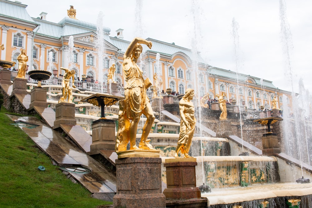 gold statue of man riding horse near white concrete building during daytime