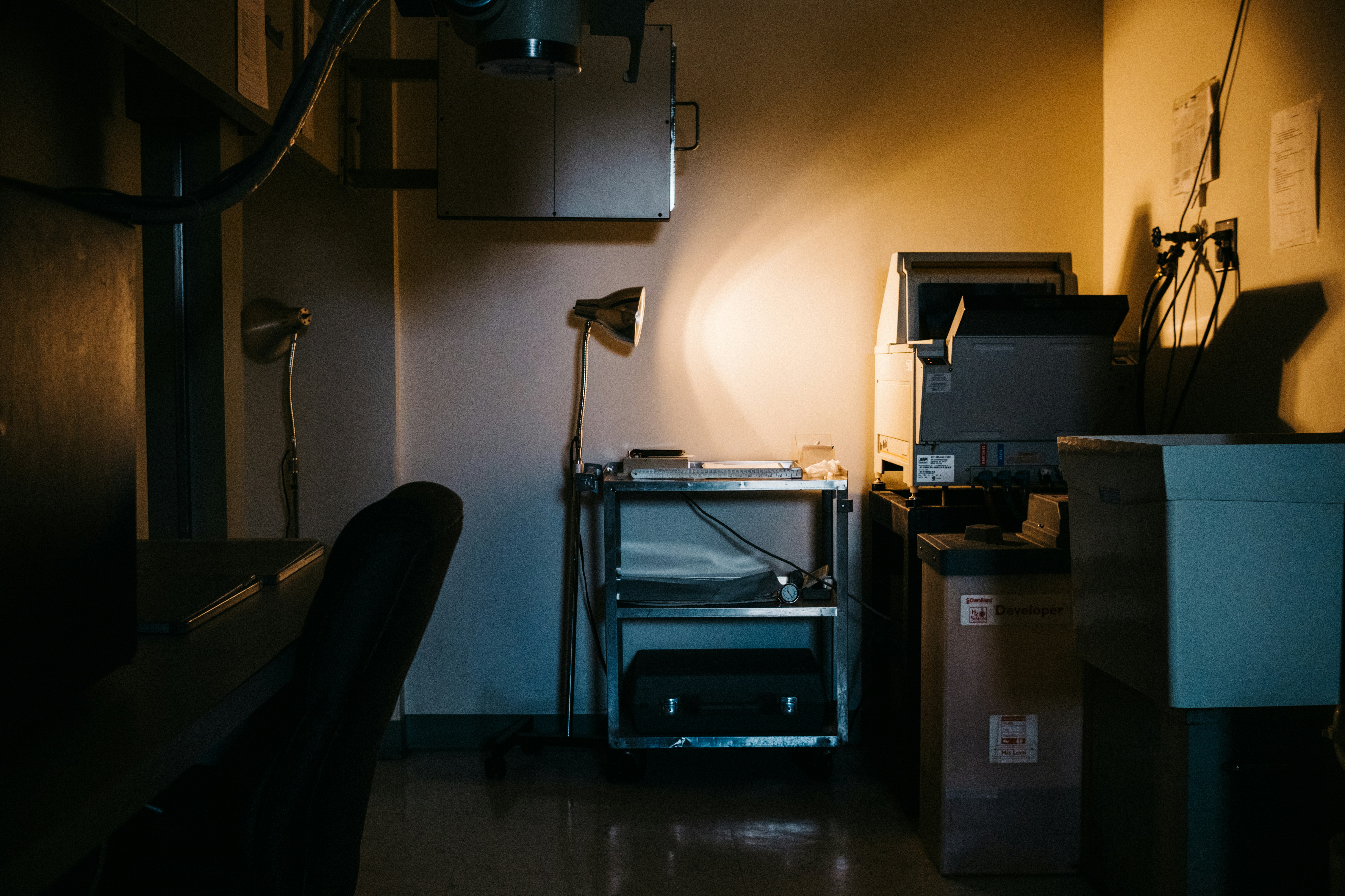 Spécialistes médicaux en consultation dans un hôpital sombre, éclairage dramatique en clair-obscur, atmosphère clinique