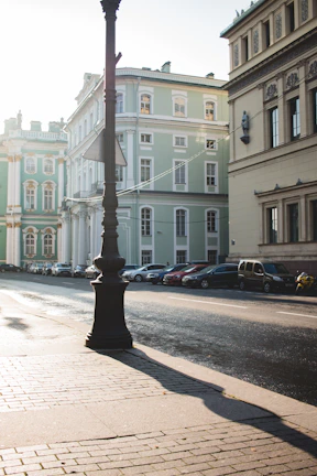 Sunlit street scene in Old Batumi featuring classic buildings and cobblestone pavement.