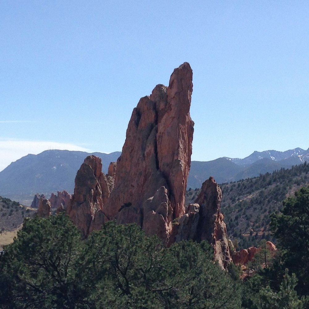 brown rock formation near green trees during daytime