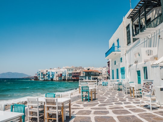 white and brown concrete buildings near sea during daytime in Little Venice Greece