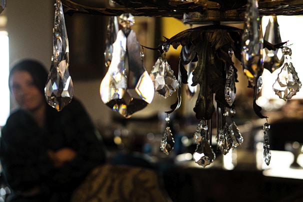 A close-up of a crystal pendant glowing softly against a dark, textured background.