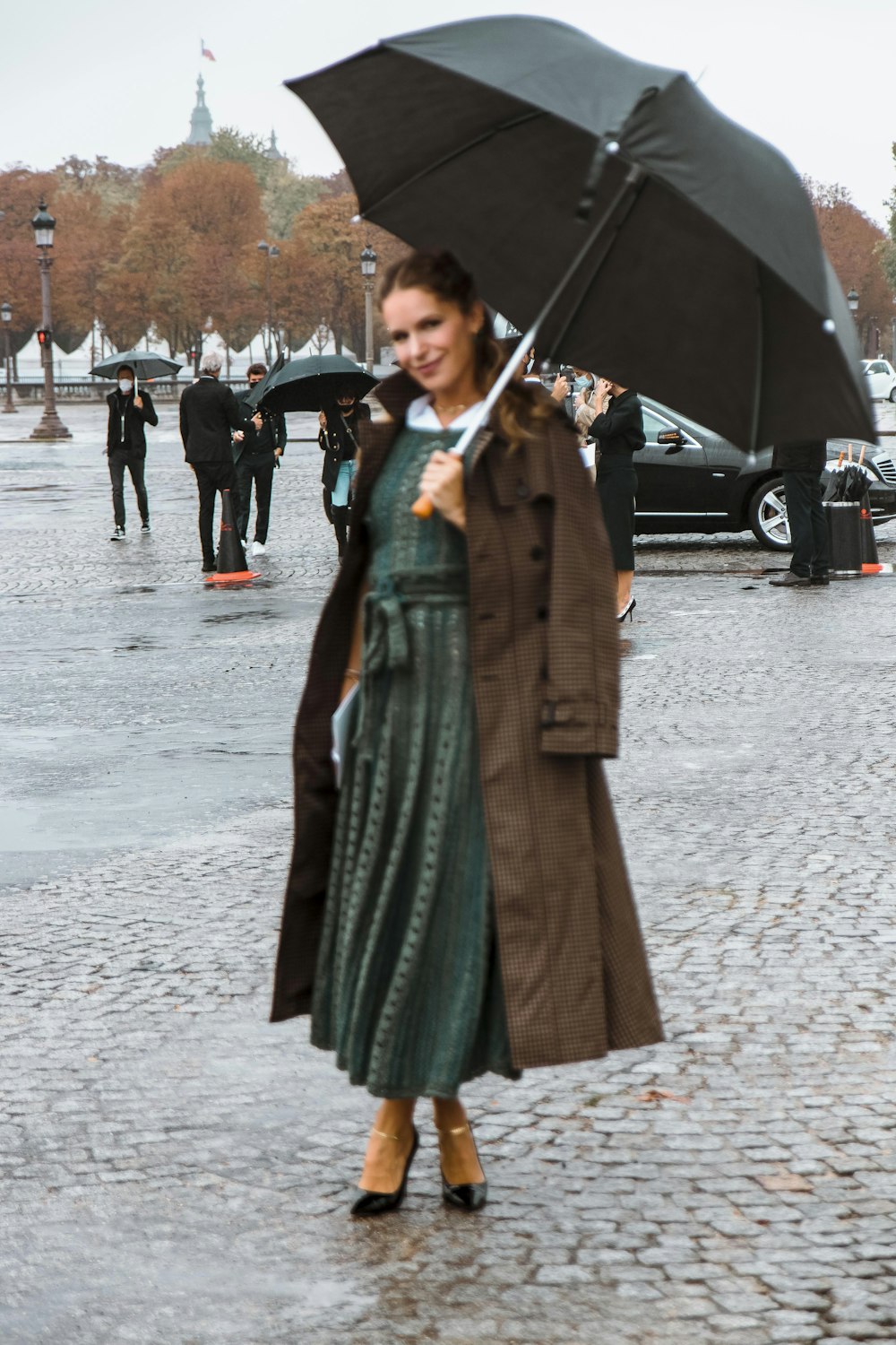woman in green coat holding umbrella