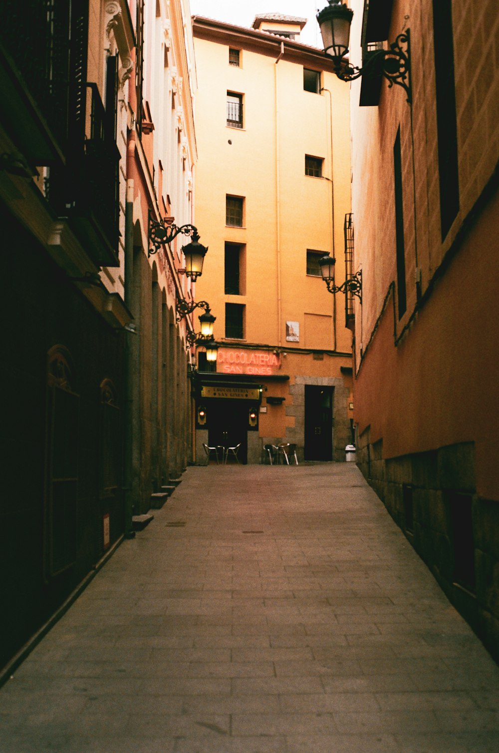 empty hallway between concrete buildings during daytime