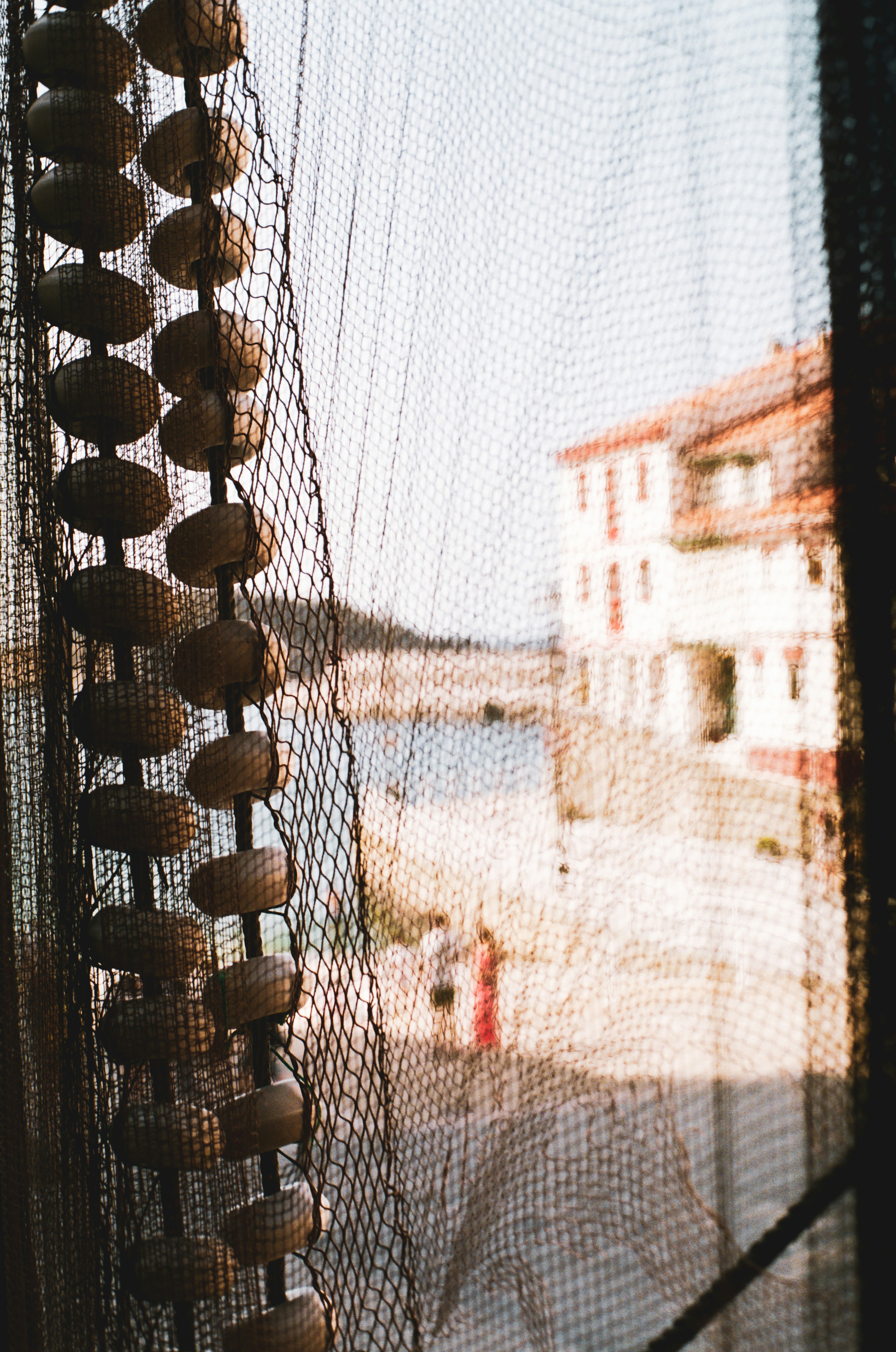 View of a couple talking through a fishing net in the Austurian village of Cudillero.