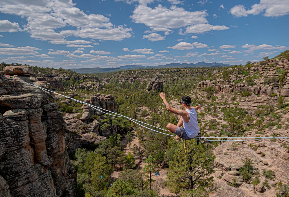 man in white t-shirt climbing on mountain during daytime