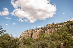 brown rocky mountain under blue sky and white clouds during daytime