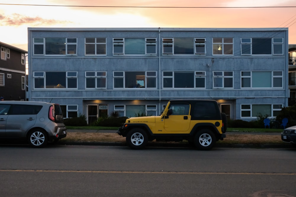 yellow and black suv parked beside white concrete building during daytime