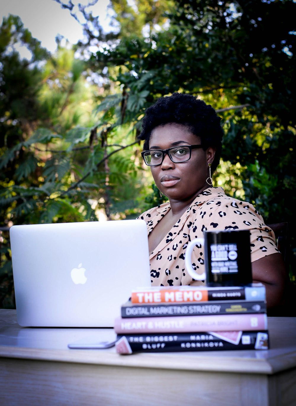woman in white and black leopard print shirt using macbook