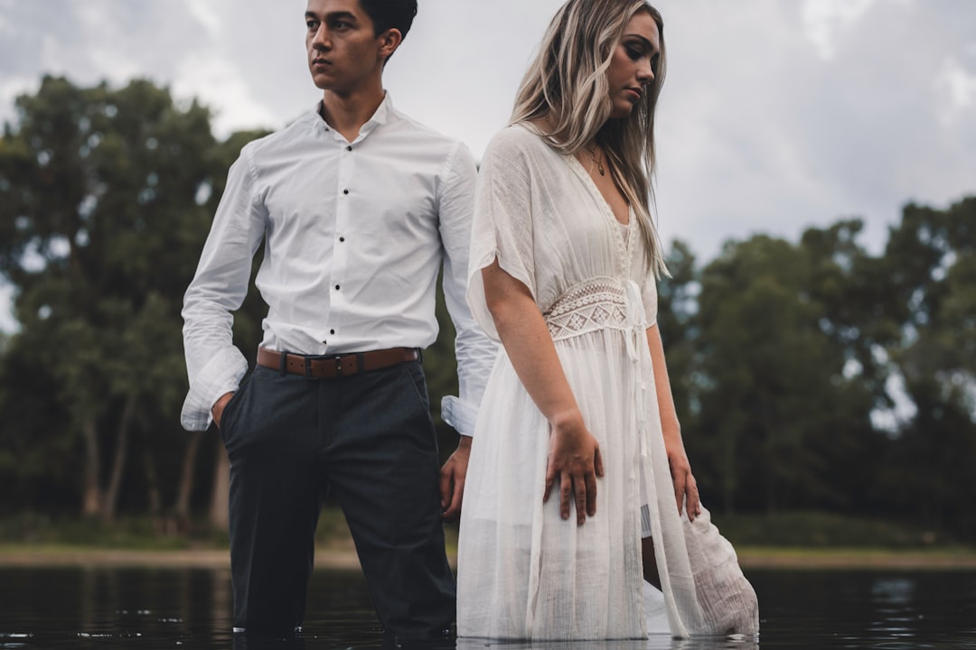 man in white button up shirt and black pants holding woman in white dress