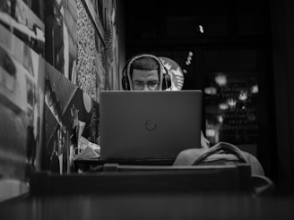 grayscale photo of man using macbook