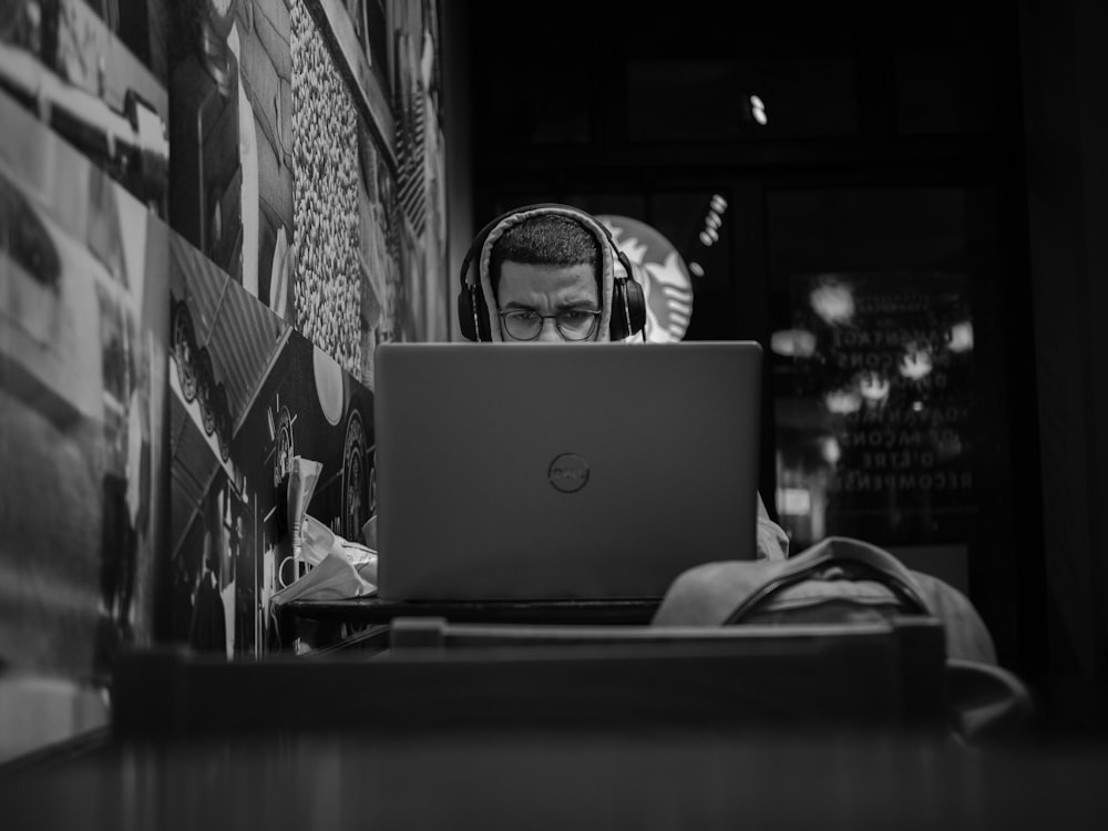 grayscale photo of man using macbook