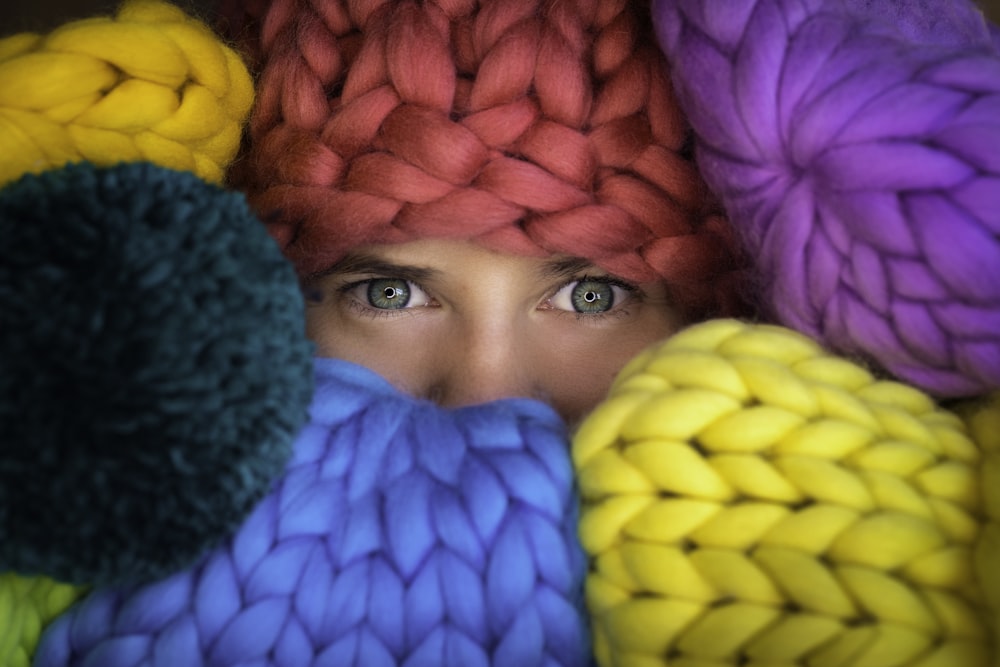 woman covering her face with green yellow and pink textile