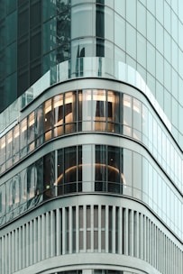 Modern downtown apartment building with large glass windows reflecting city lights.