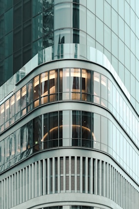 Modern downtown apartment building with large glass windows reflecting city lights.