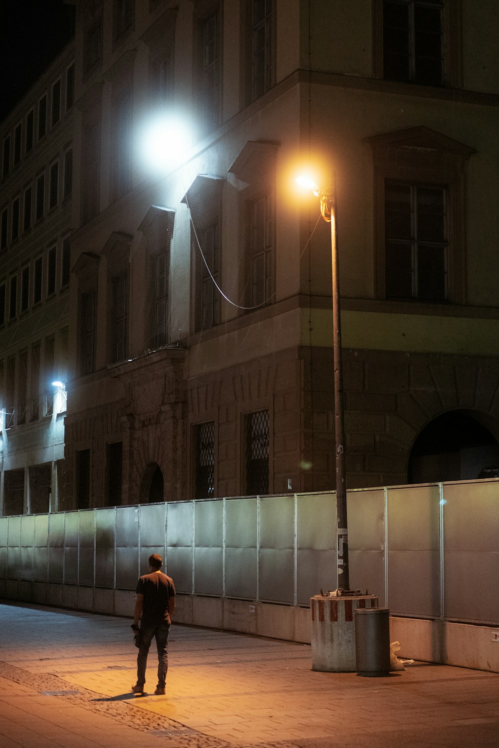 woman in red coat walking on sidewalk during night time