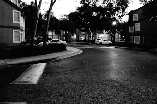 A group of town workers installing new streetlights along a residential road at dusk.