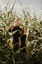 woman in black sleeveless dress sitting on corn field