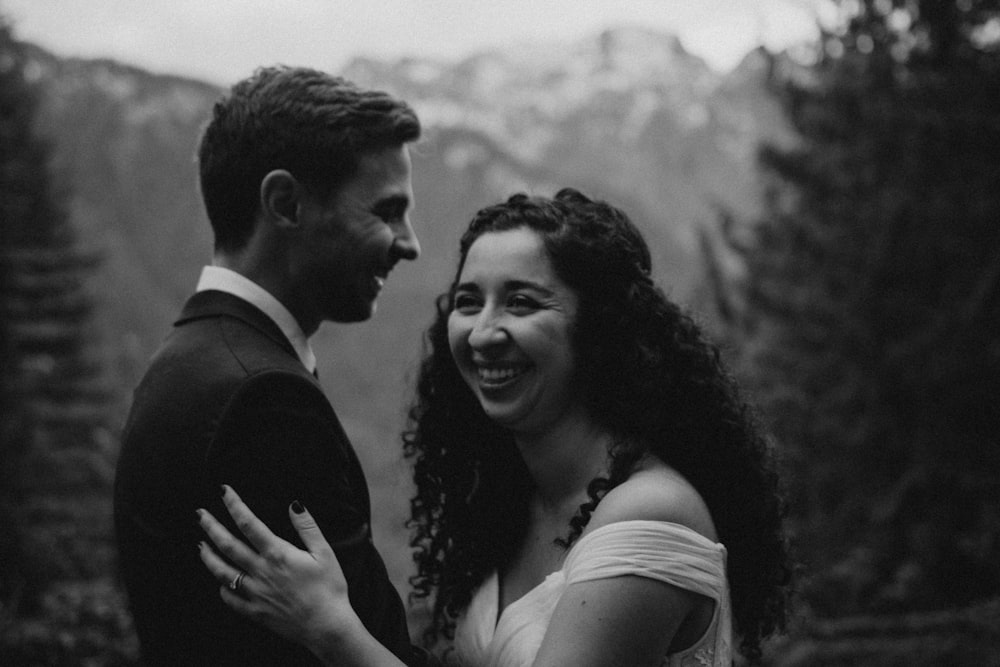 man in black suit kissing woman in white sleeveless dress