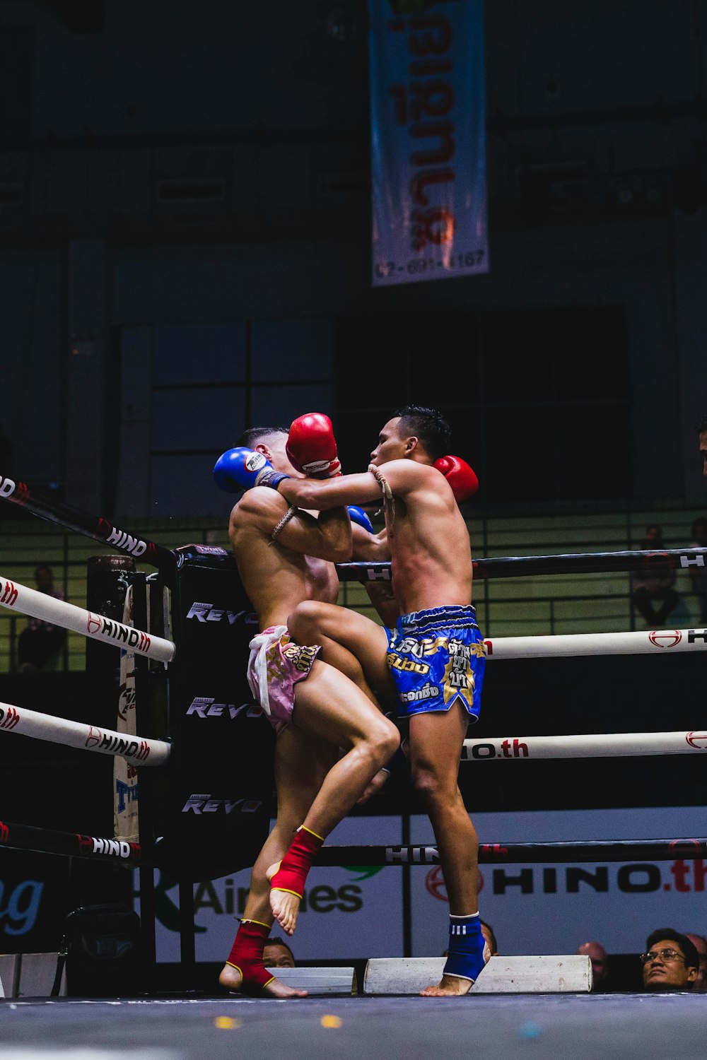 2 men in blue and red shorts and boxing gloves
