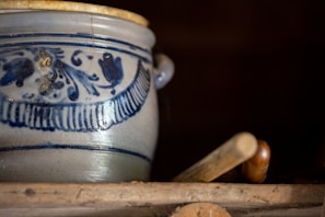 Close-up of a vibrant 3D printed pot with geometric patterns on a wooden shelf