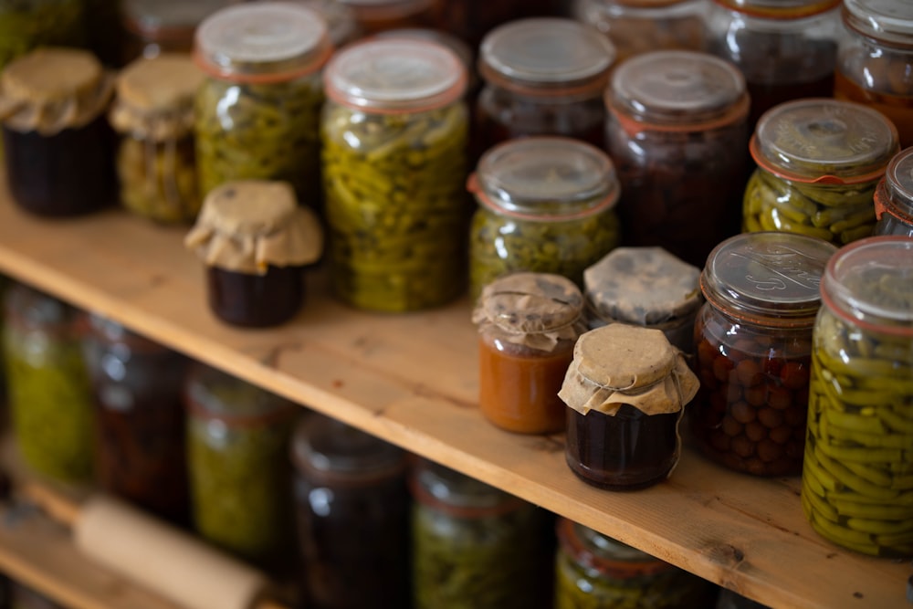 clear glass jars on brown wooden shelf