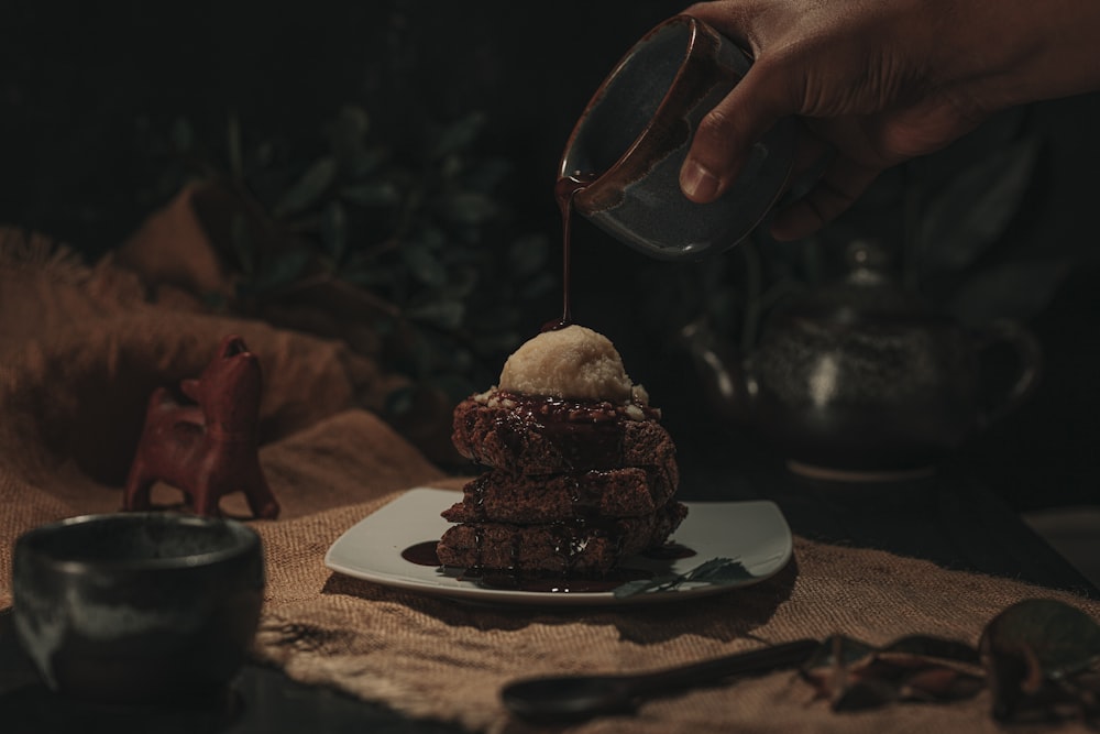 person pouring water on cupcake