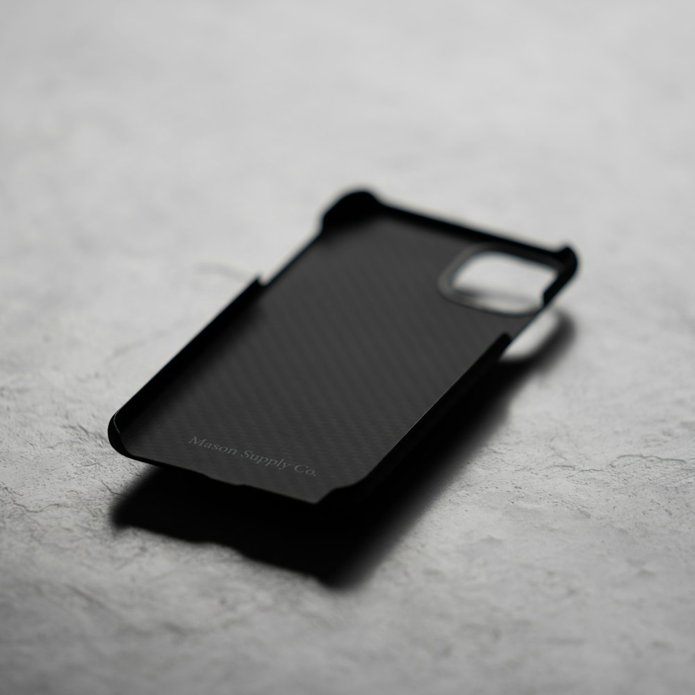 black iphone case on white textile