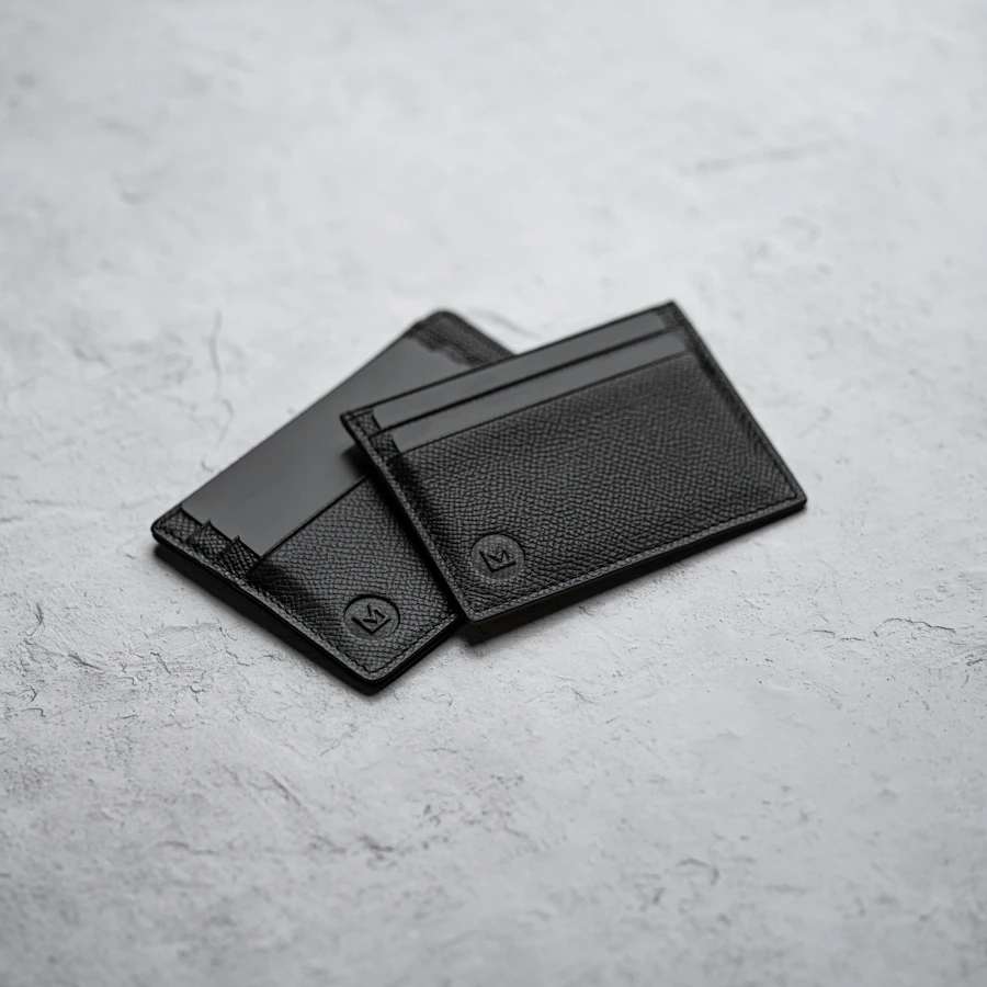 Black leather business card case on a white surface