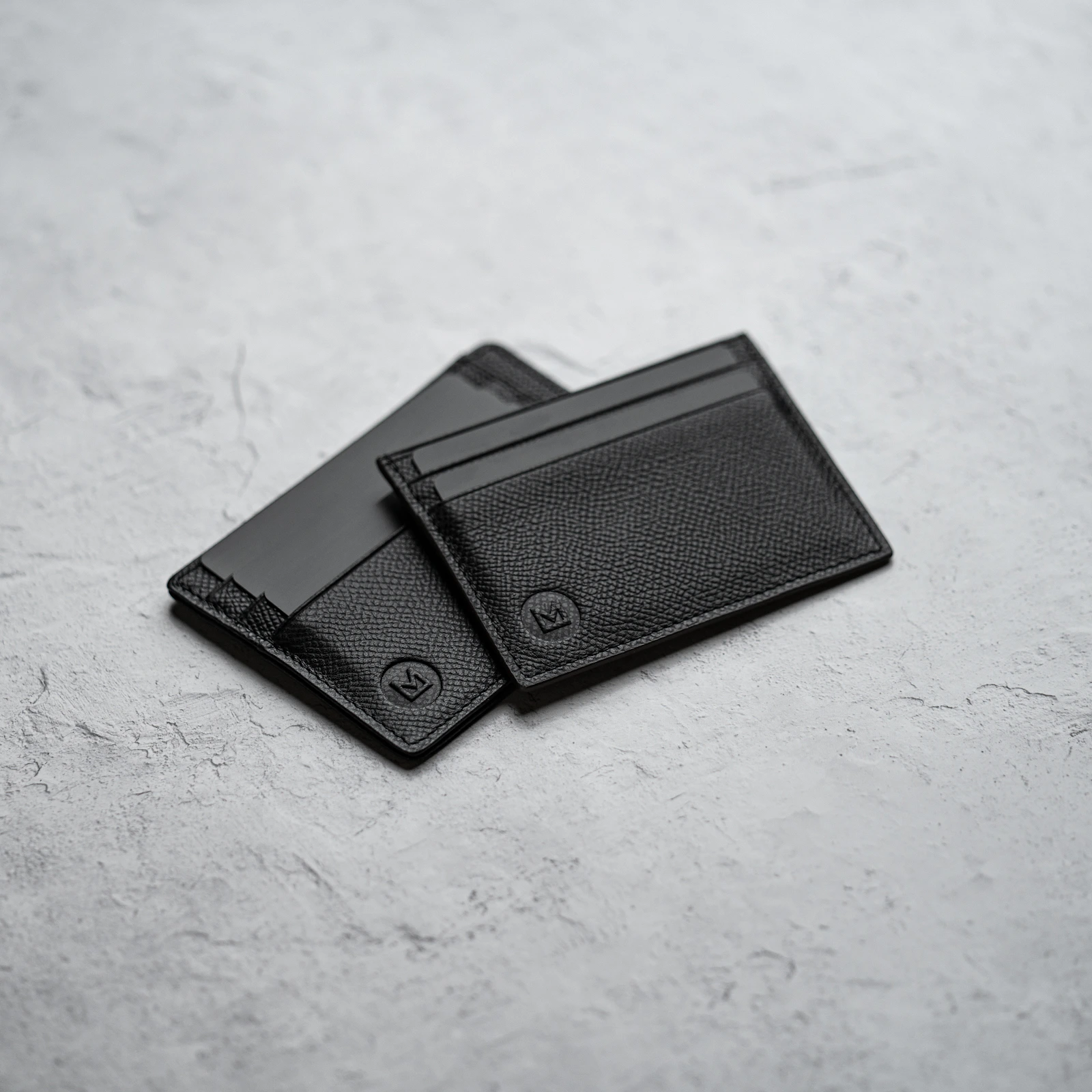 Black leather card holders on concrete