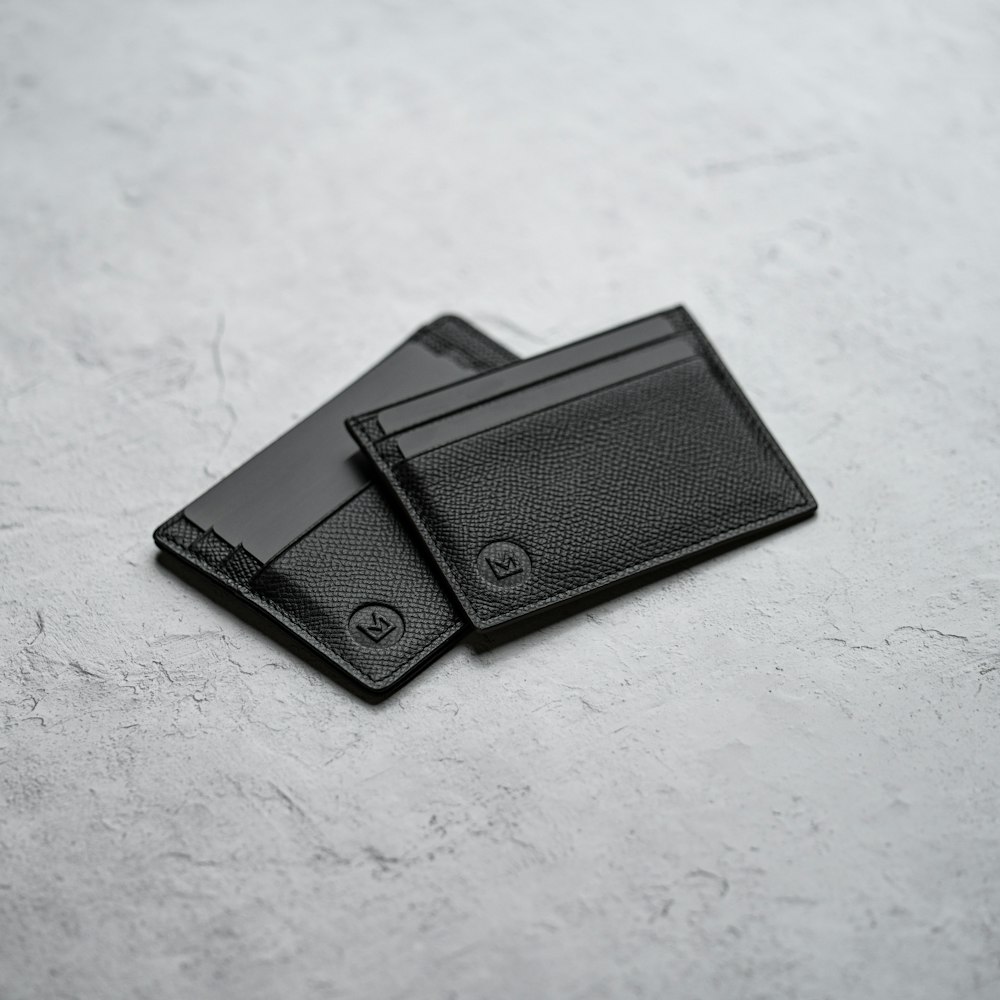 black leather bifold wallet on white surface