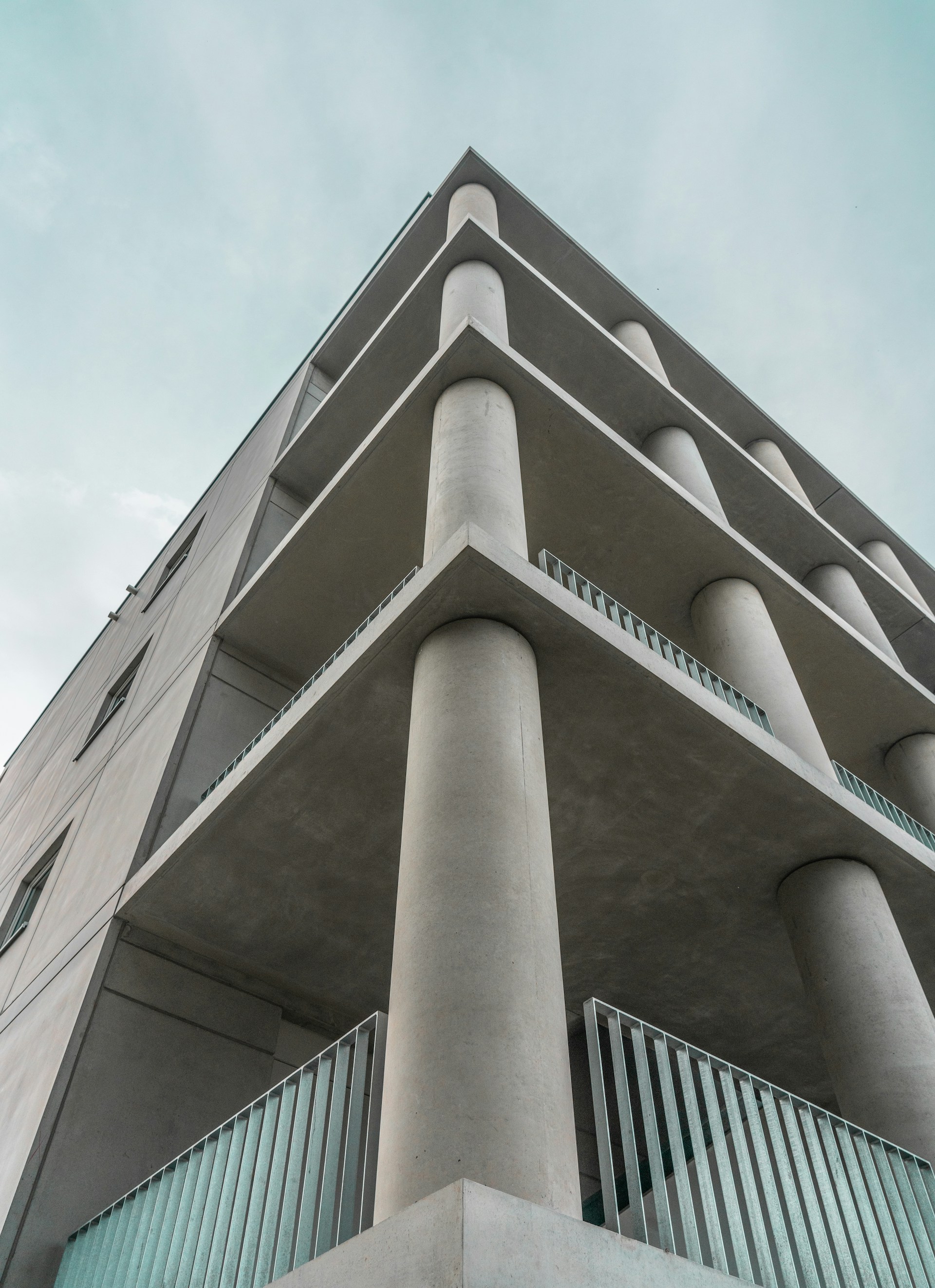 low angle photography of gray concrete building under blue sky during daytime