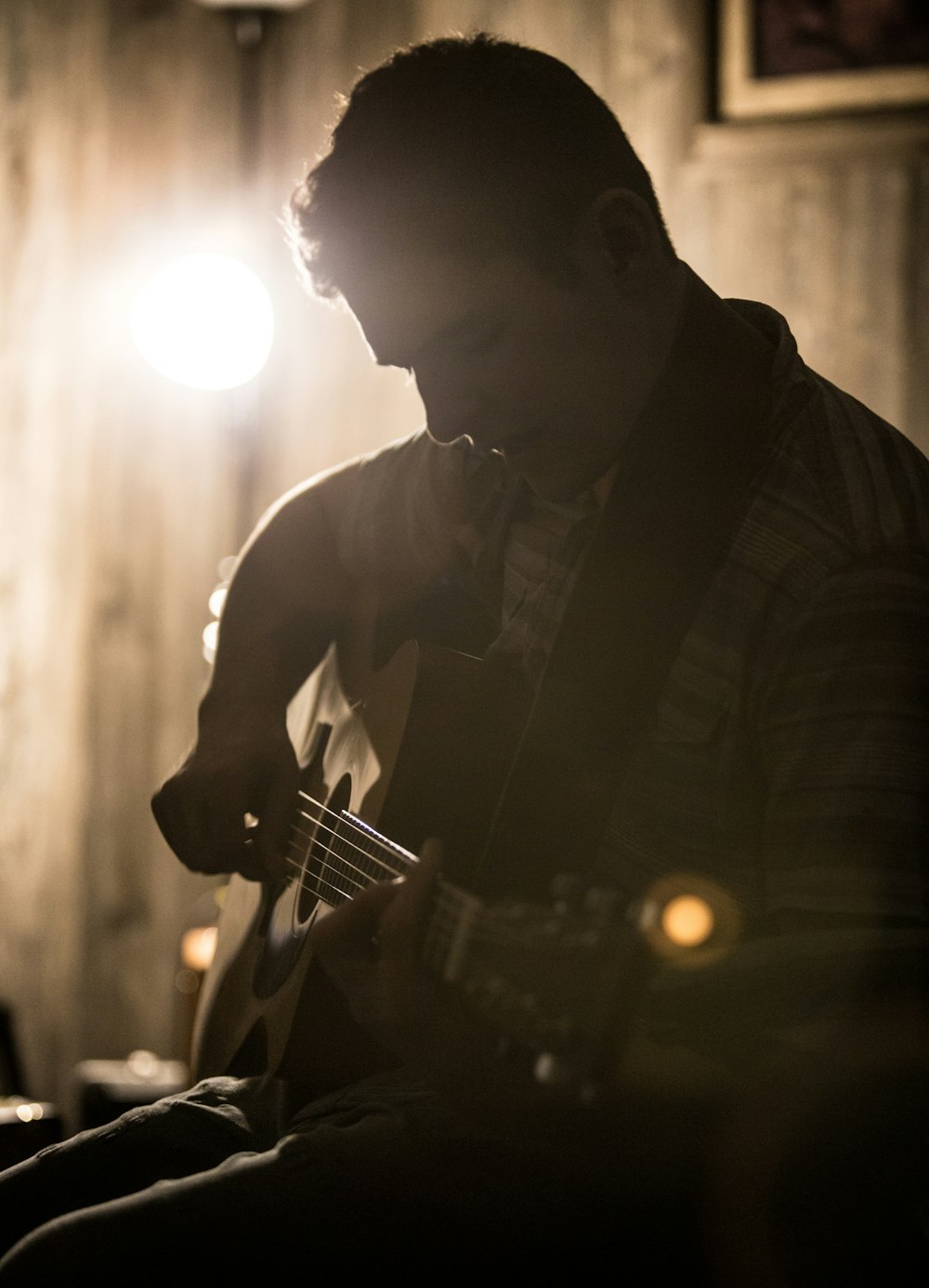 man playing guitar in grayscale photography