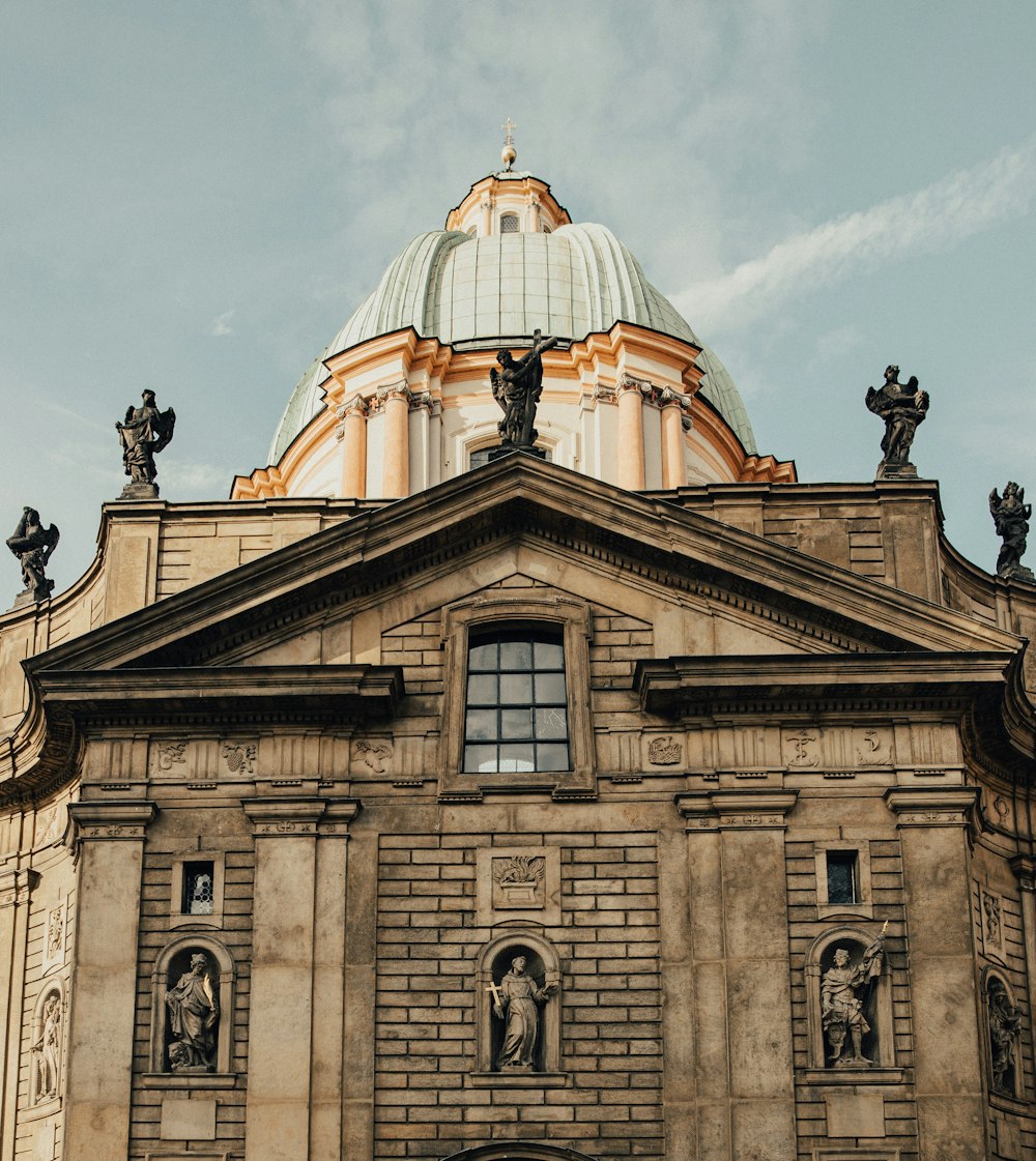 brown concrete church under white clouds during daytime