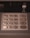A close-up view of a numeric keypad typically found on ATMs, featuring metal buttons numbered 0 to 9, along with function keys labeled in another language. The panel includes instructions for envelope deposit.