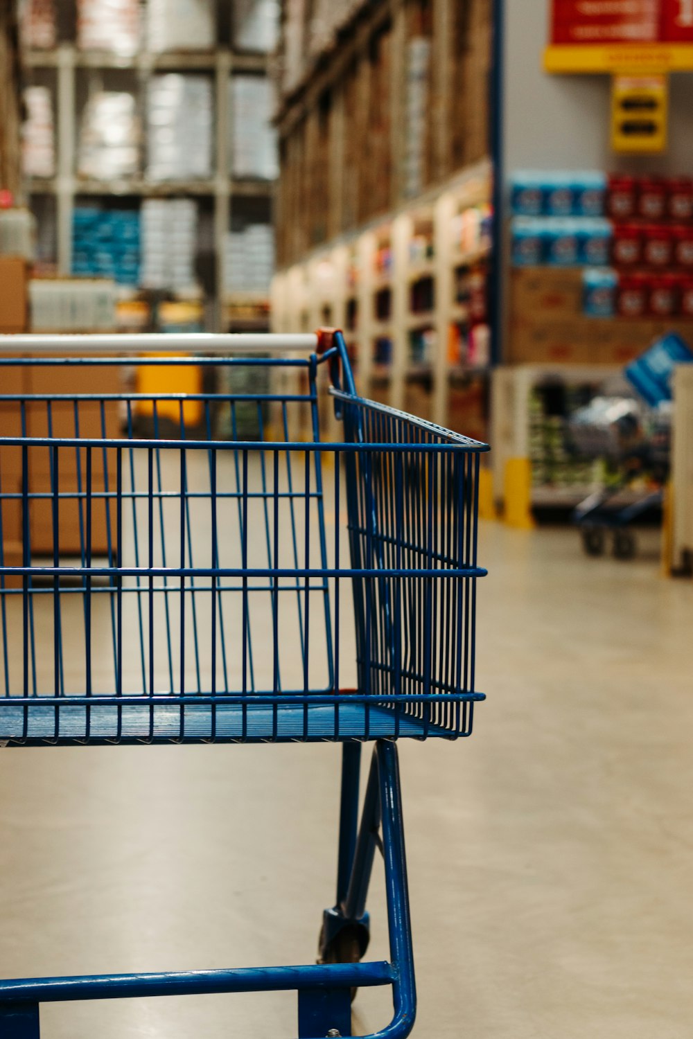 carrello della spesa blu su pavimento bianco