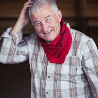 man in white and black plaid dress shirt wearing red scarf