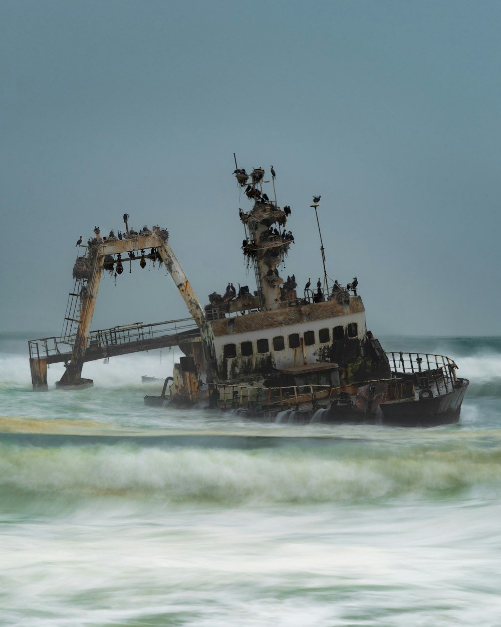 brown ship on sea under white clouds during daytime