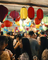 A vibrant celebration of Hari Raya, with families sharing meals and laughter under colorful lanterns.