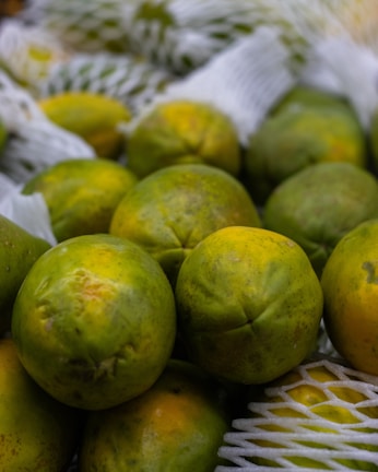 green round fruits on white textile