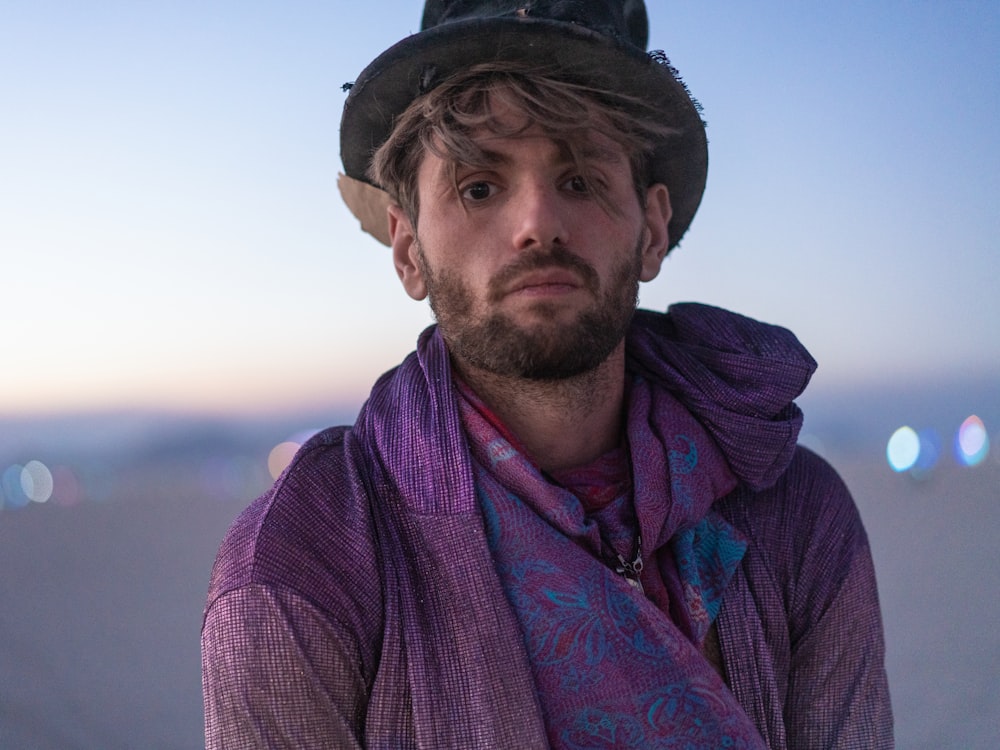 man in black knit cap and red and blue scarf