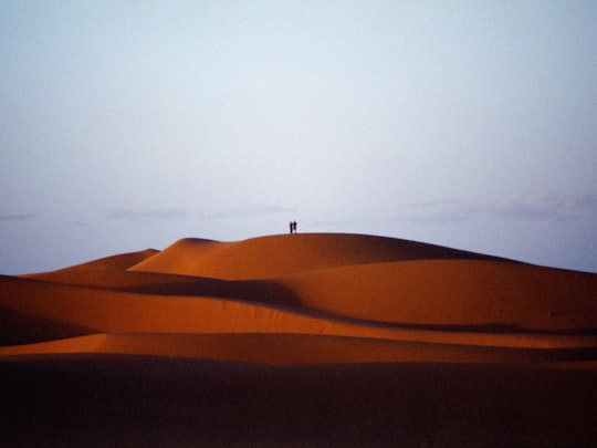 brown sand under white sky during daytime in Merzouga Morocco