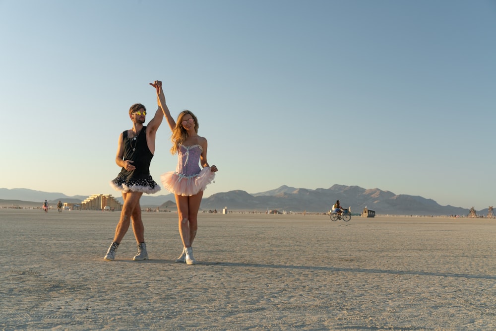 woman in pink dress running on gray sand during daytime