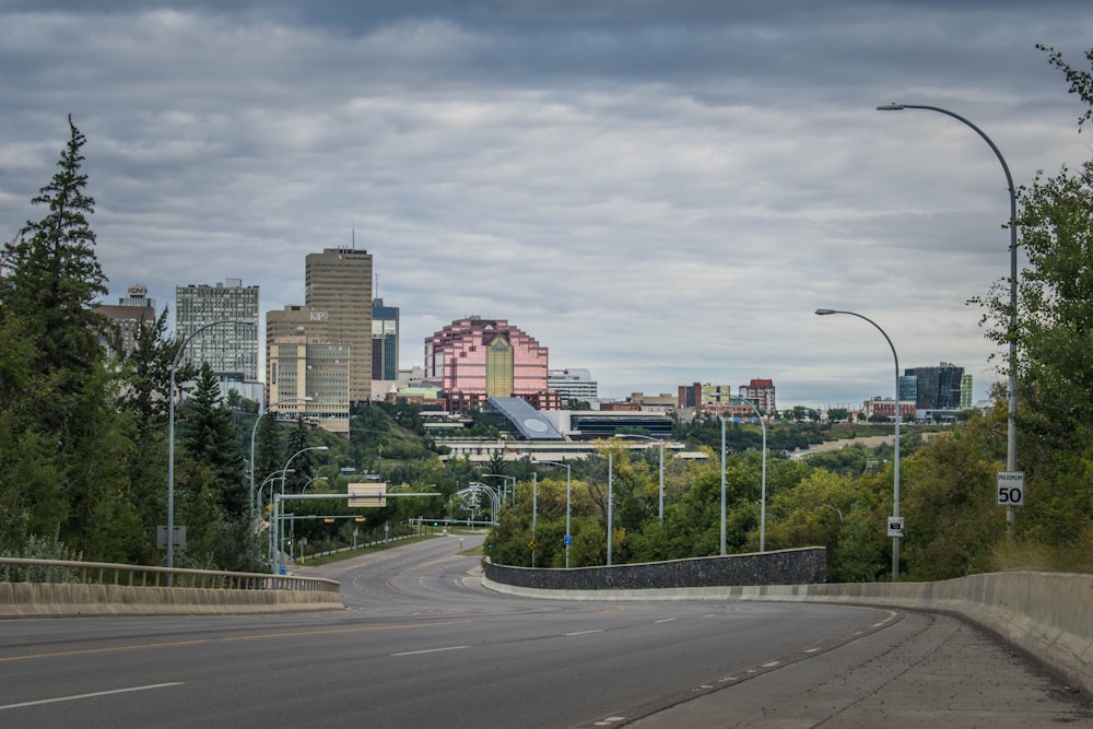 city buildings near green trees under white sky during daytime