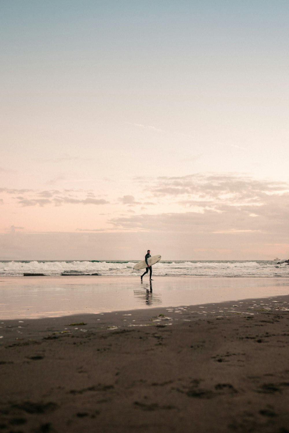 silhueta do homem que anda na praia durante o dia