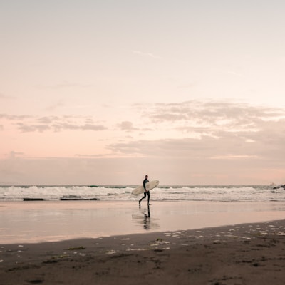 silhouette of man walking on beach during daytime