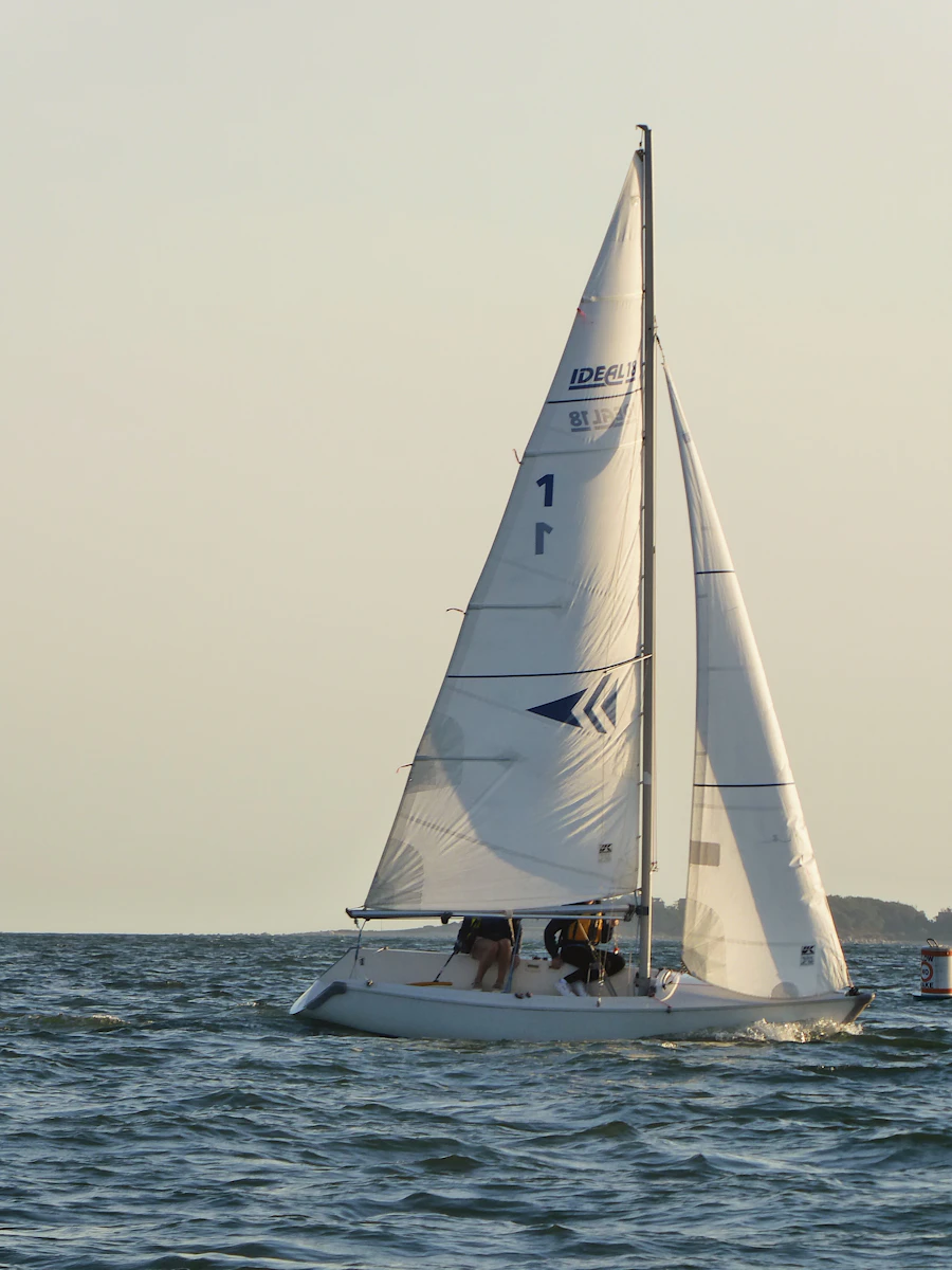 A sail filled with wind on blue water during an improver course